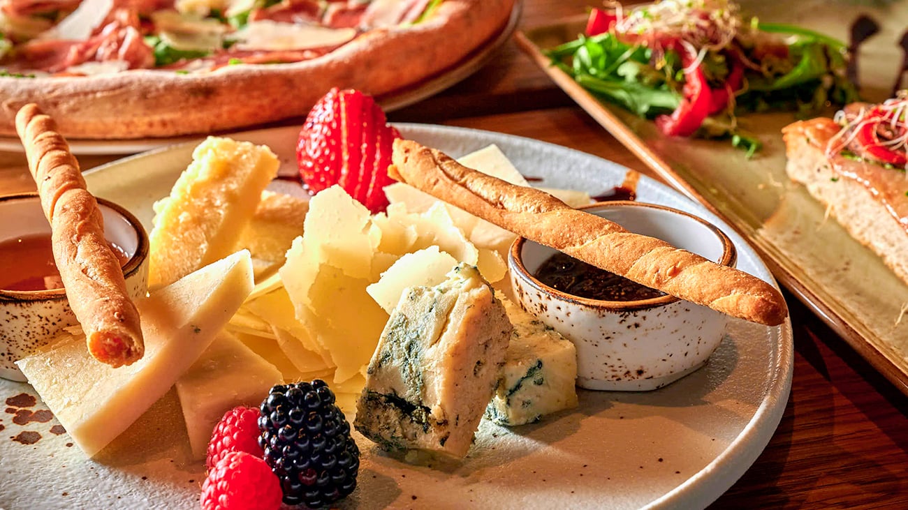 Tapastallerken med forskjellige oster og grissini.