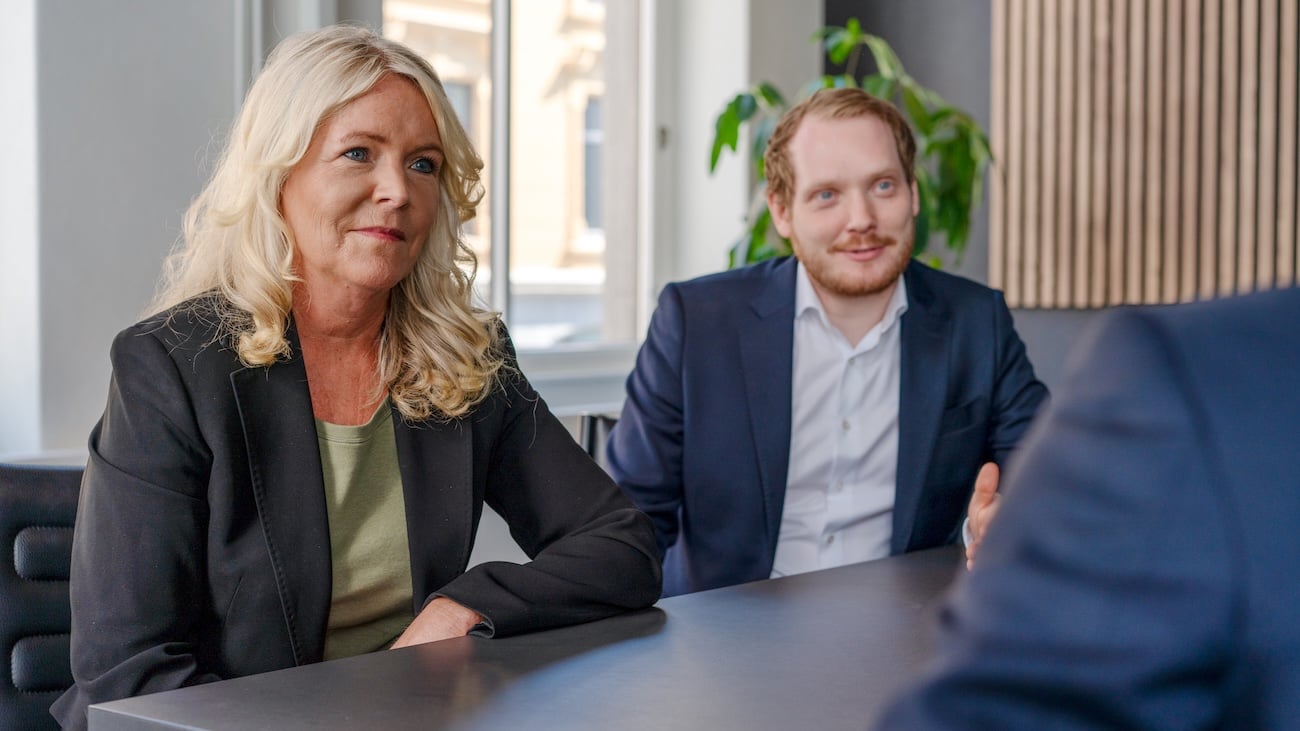 Kvinnelig og mannlig i dialog med klient, som man kun ser skulderen til.