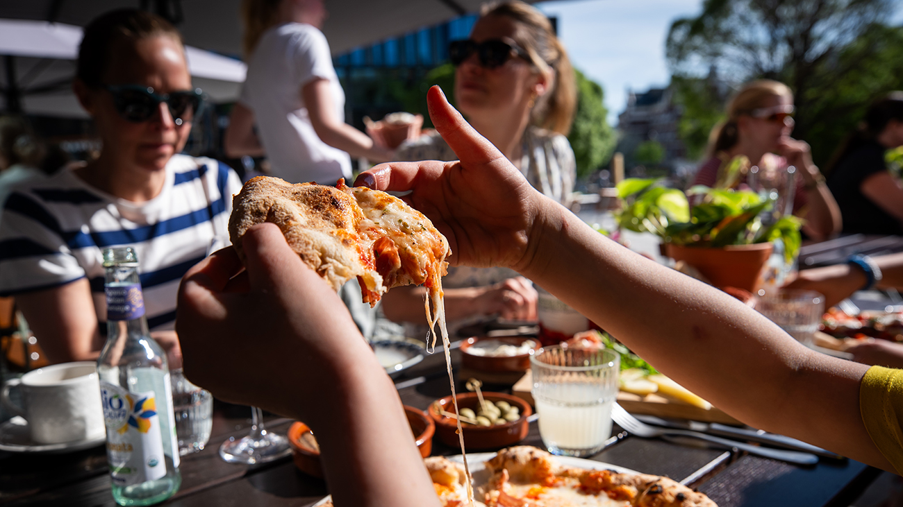 Unge mennesker som spiser pizza ute på restauranten Crudo på Nydalen.