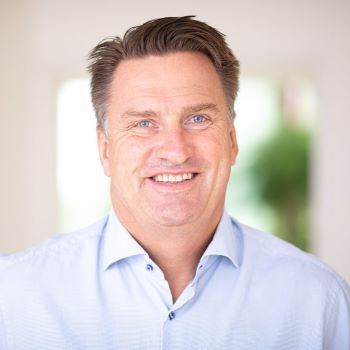 Formelt kledd mann som smiler til kamera.