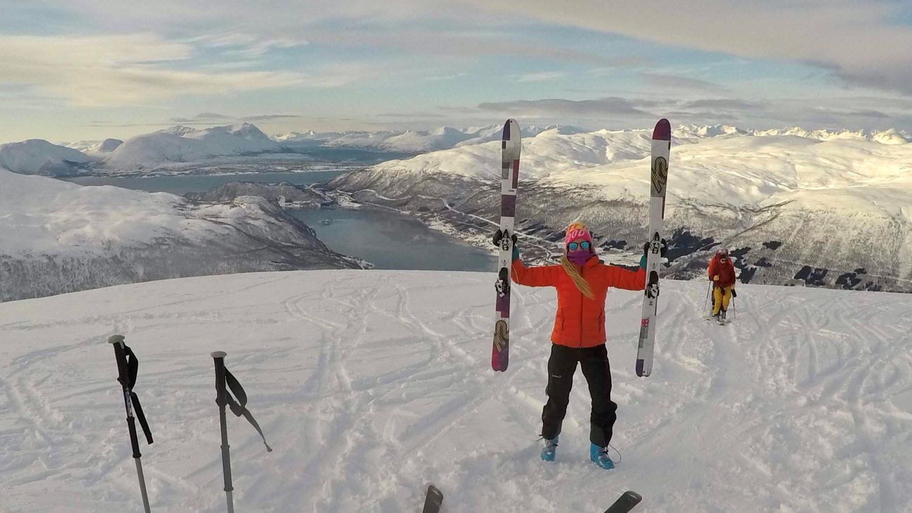 Dame med ski på toppen av bakken