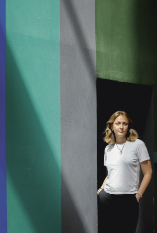 Ung kvinne som poserer foran en vegg i ulike farger
