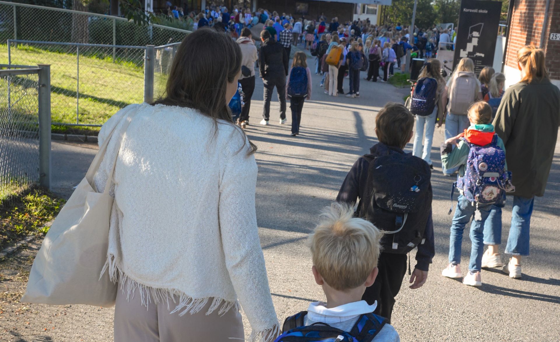 Mor og sønn på vei inn i skolegården.