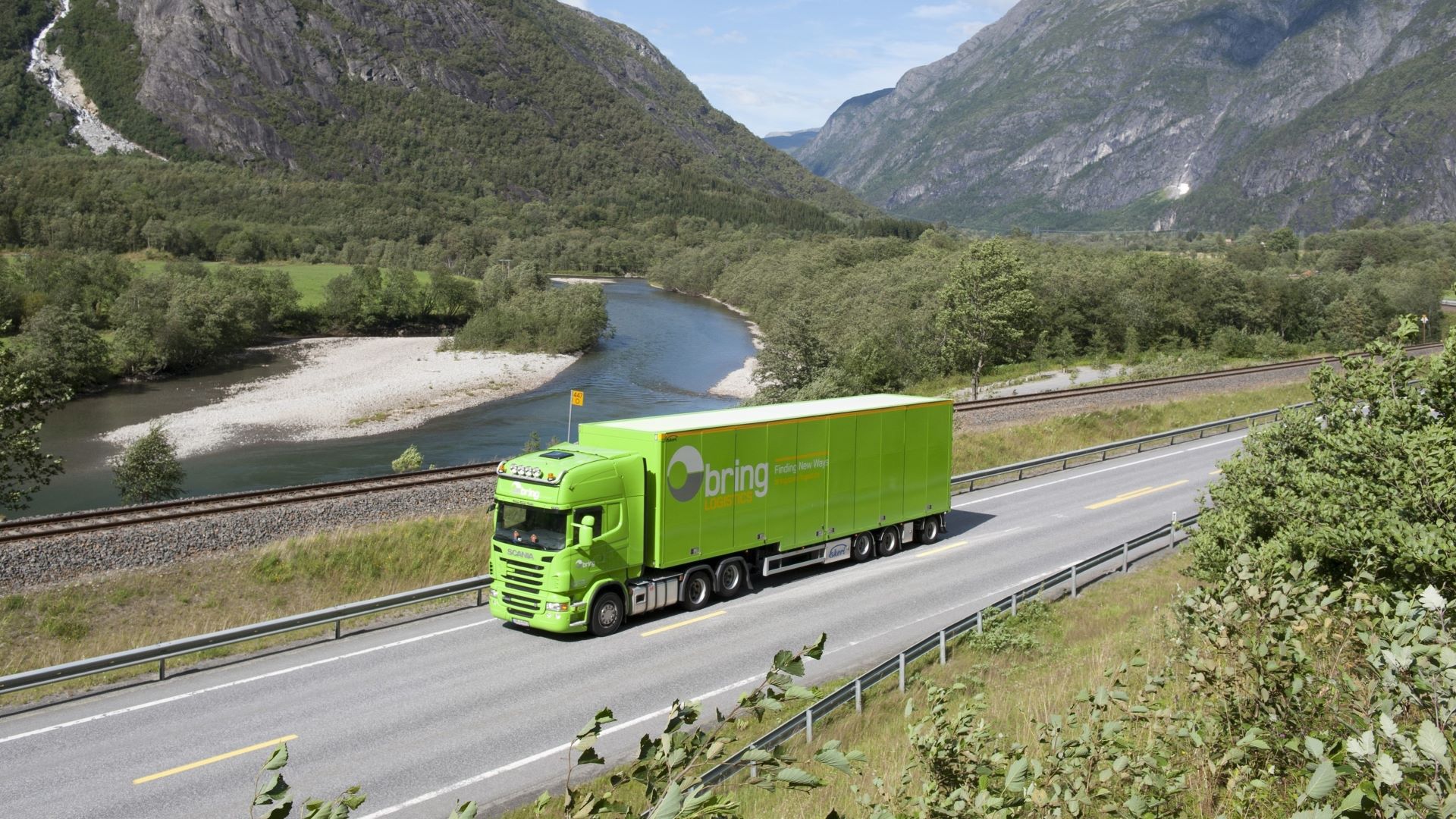 En grønn Bring-trailer langs norske veier med fjell i bakgrunnen.