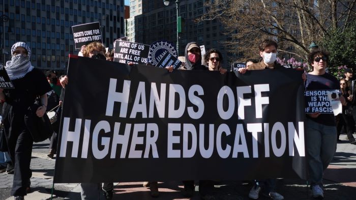 En demonstrasjon der demonstrantene holder et banner med teksten "Hands off higher education".