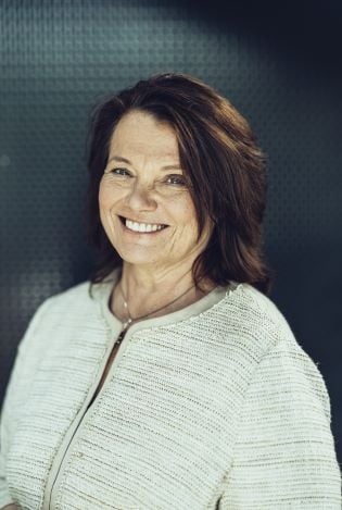 Kvinne som smiler bredt til kamera.